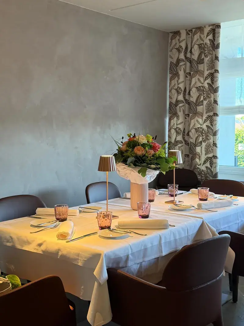 Gedeckte Tafel mit Tischlampen vor dem Vorhang